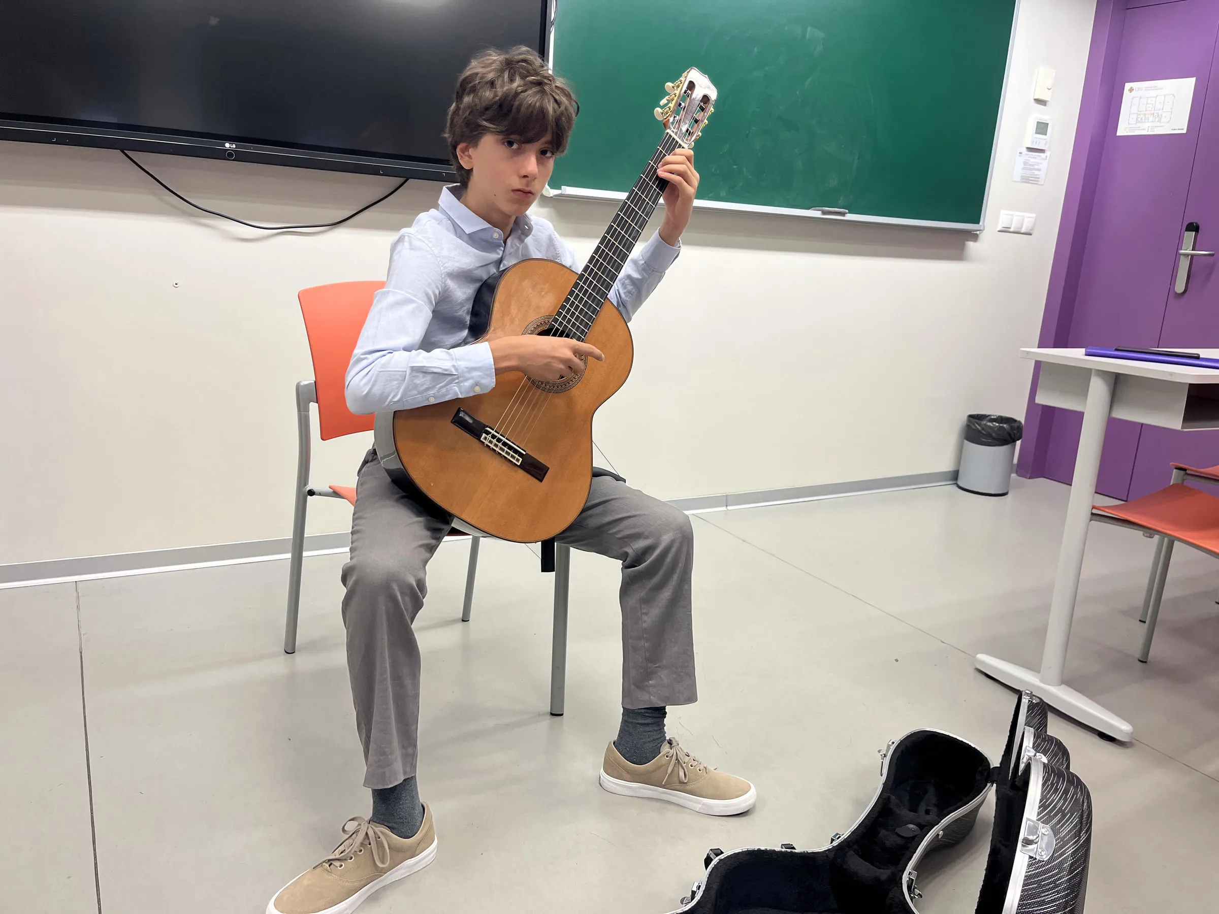 Nestor with his guitar in the course classroom at Elche.